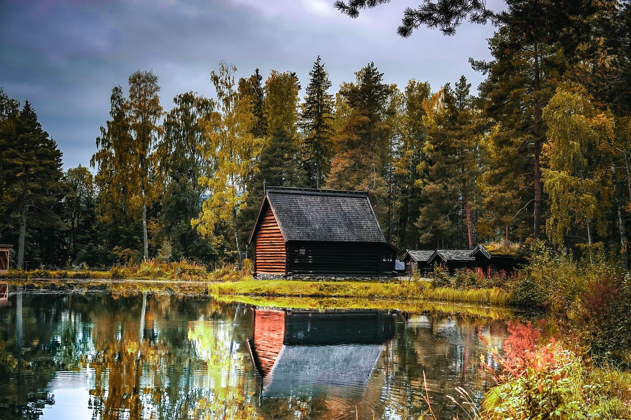 Lakeside cabin surrounded by autumn trees