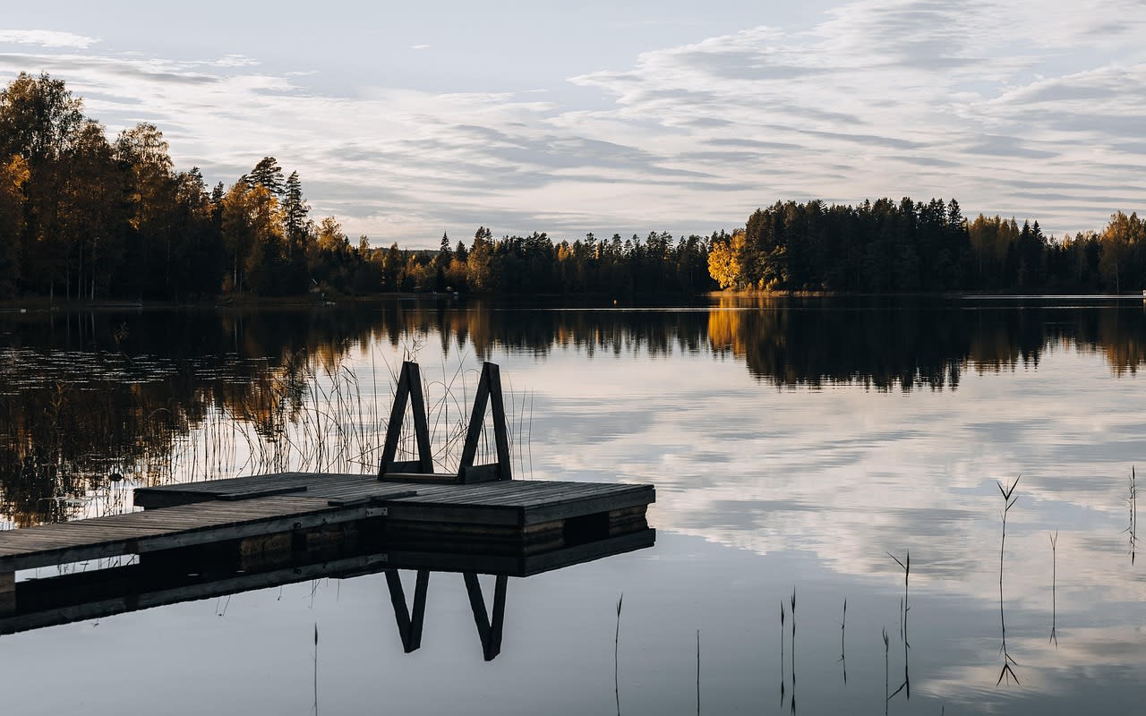 Wooden dock with a swim ladder on a still fall lake