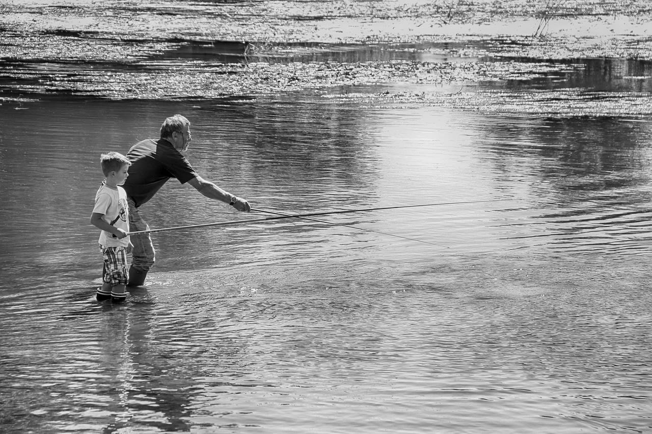 Grandfather and grandson fishing in a lake