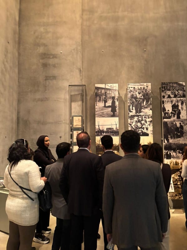 Visitors viewing a Holocaust exhibition of historical photographs