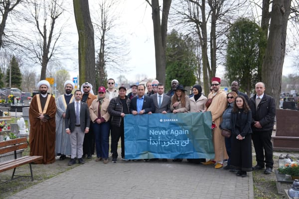 Delegation gathered with the Never Again banner at the cemetery