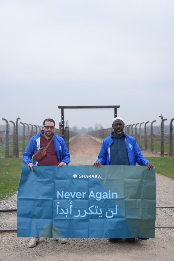 Delegates holding the Never Again banner on the Birkenau railway
