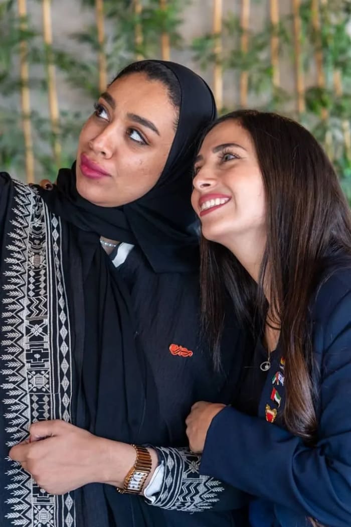 Two women smiling together at a Sharaka event