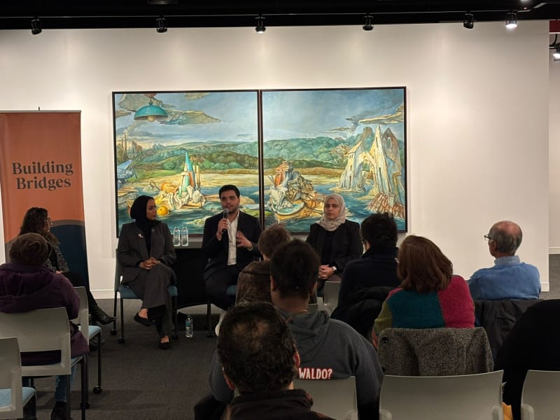Building Bridges panel discussion in a gallery in front of a painting