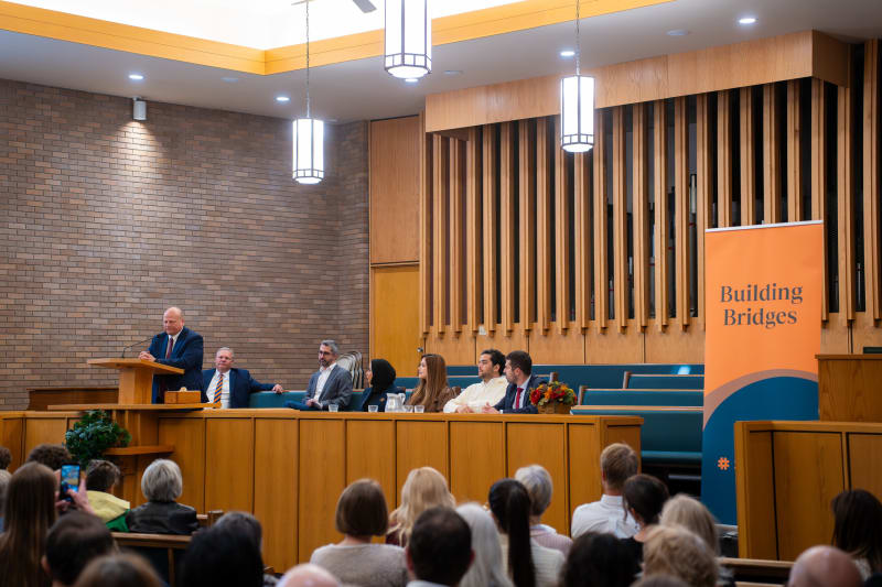Sharaka speakers on a synagogue stage before a full audience