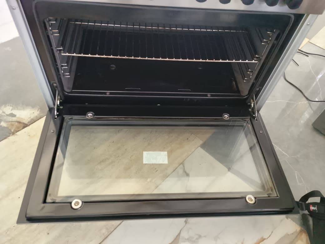 Oven interior of used Siemens freestanding gas cooker with 2 racks visible, door open