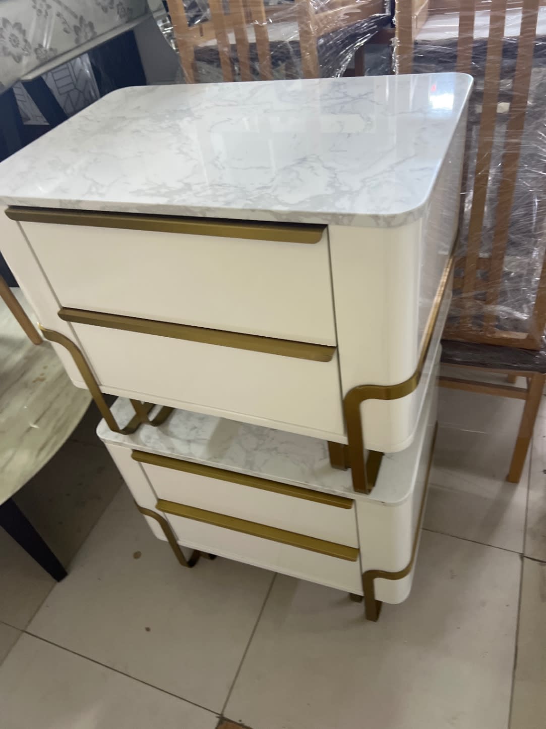 Top-down angle of used white marble top nightstand showing two drawers and gold-tone handles