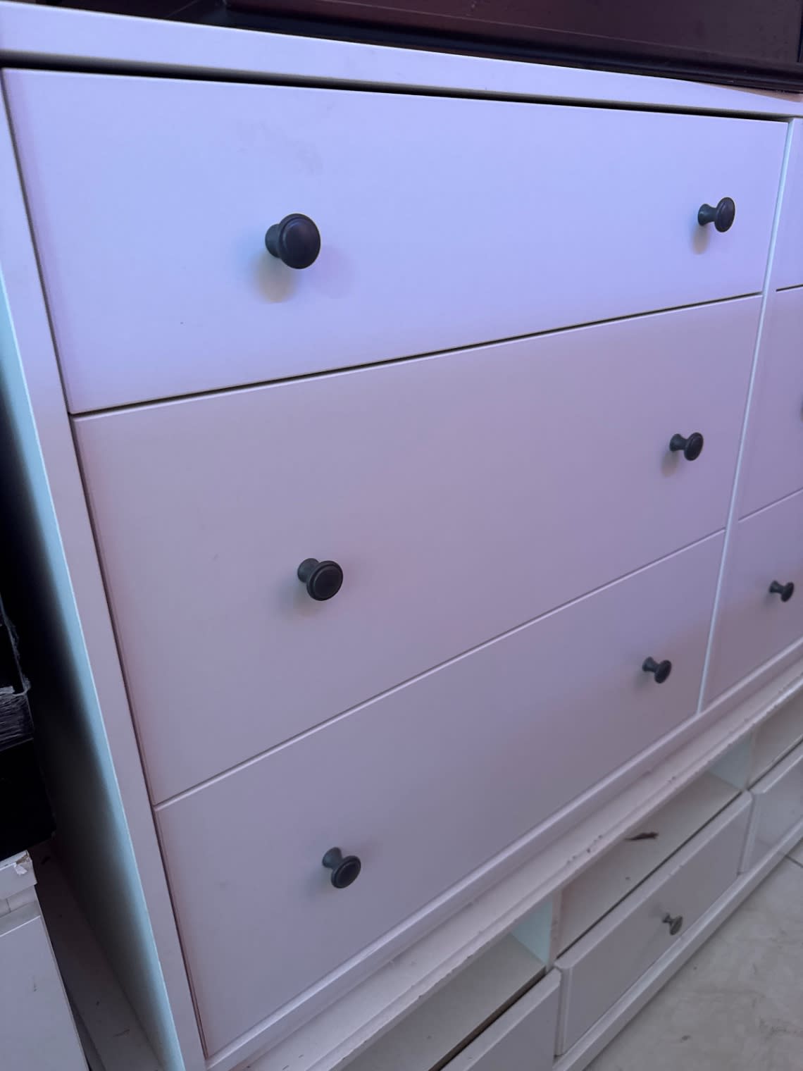 Close-up of used multi-drawer dresser drawer fronts and dark bronze knobs at Bufaisal Shop B Ajman