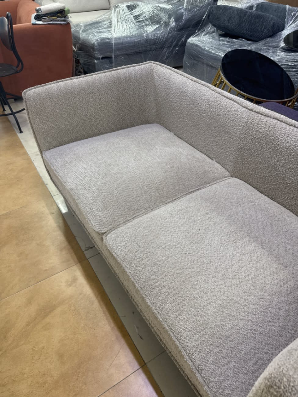 Top-down view of used 2-seater light beige boucle sofa showing seat and back cushions