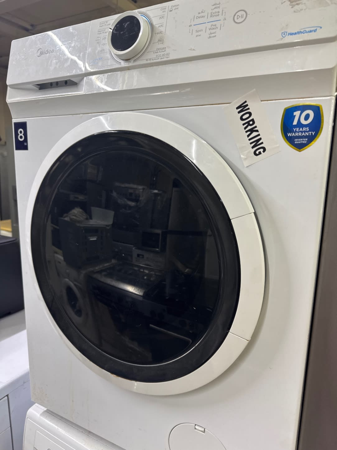 Bufaisal barcode label for used Midea 8kg front-load washing machine at Shop C Ajman
