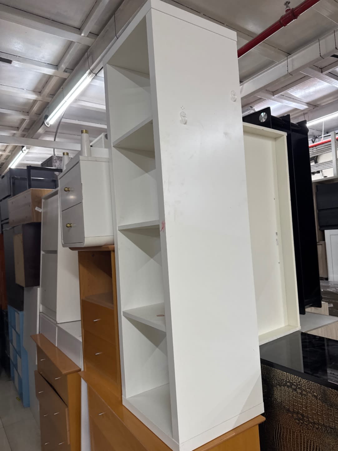 Side panel of used white tall bookshelf showing minor surface scuffs