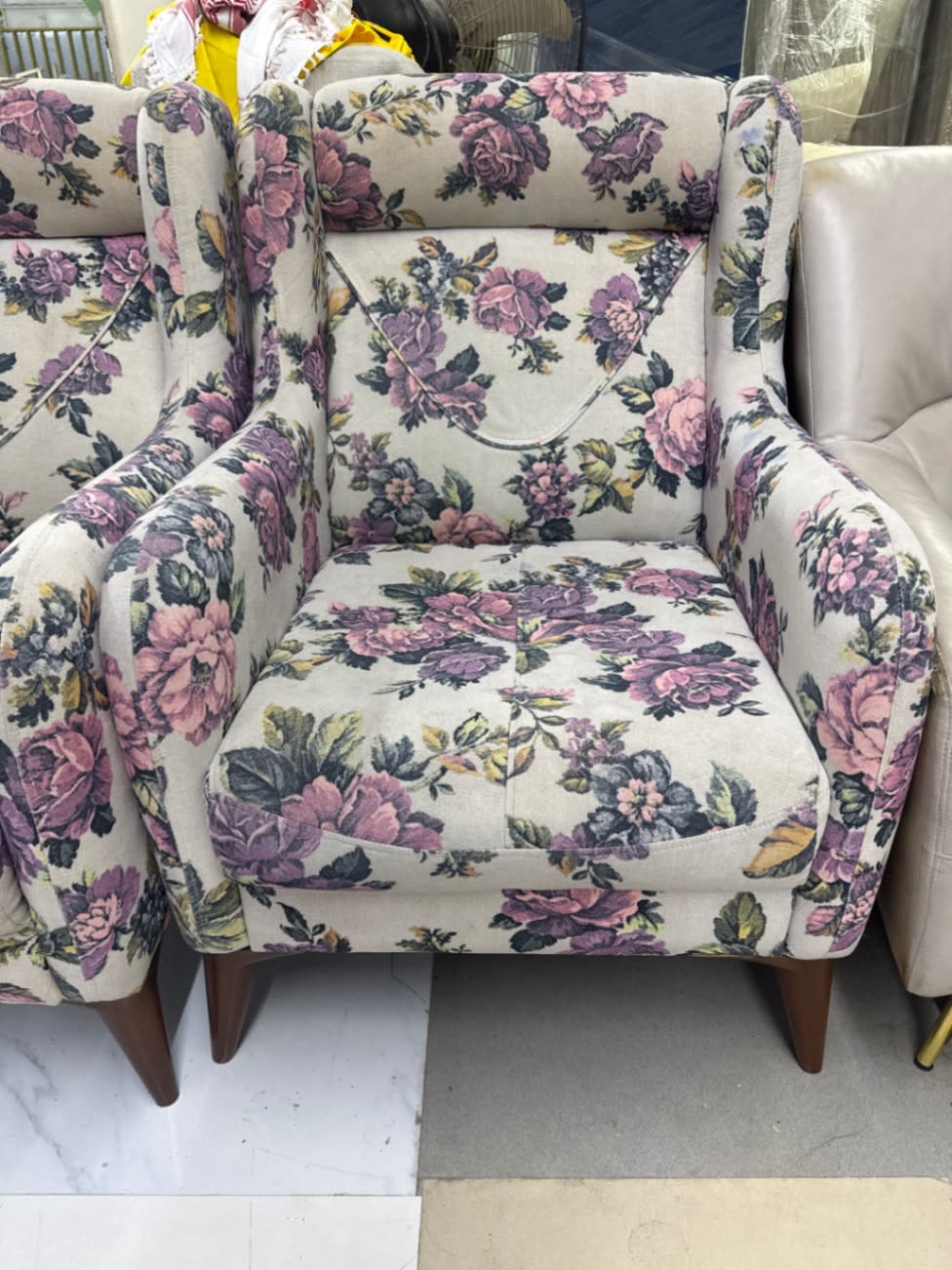 Front view of single used floral wingback armchair with dark wooden legs at Shop E Ajman