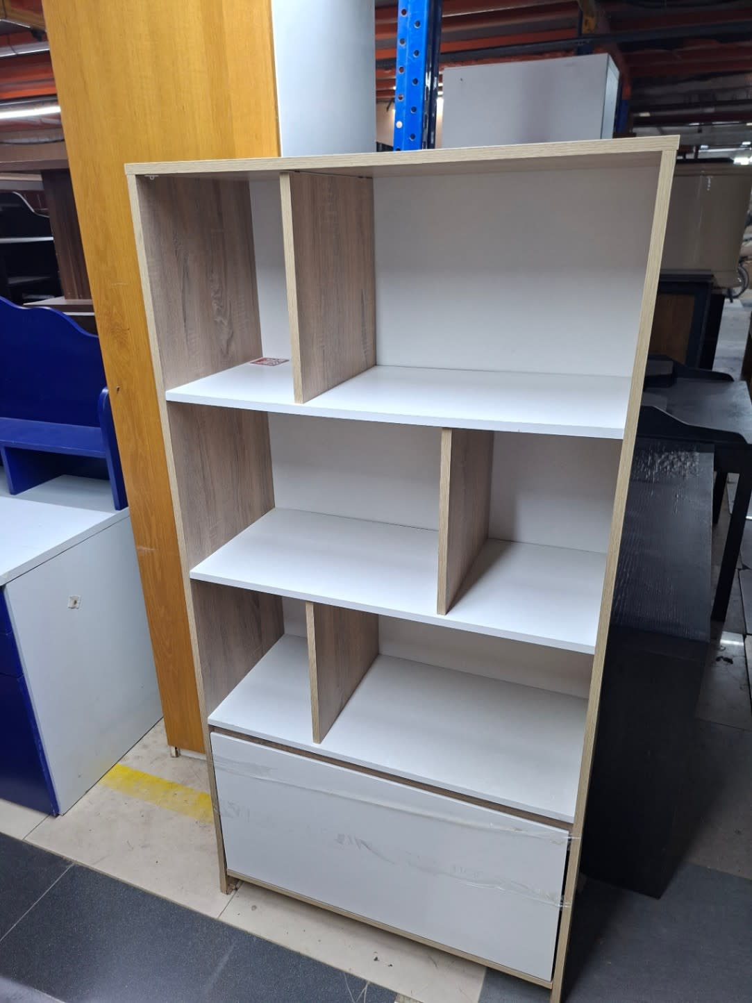Front detail of used bookshelf showing drawer scuff marks and overall good condition at Shop A Ajman