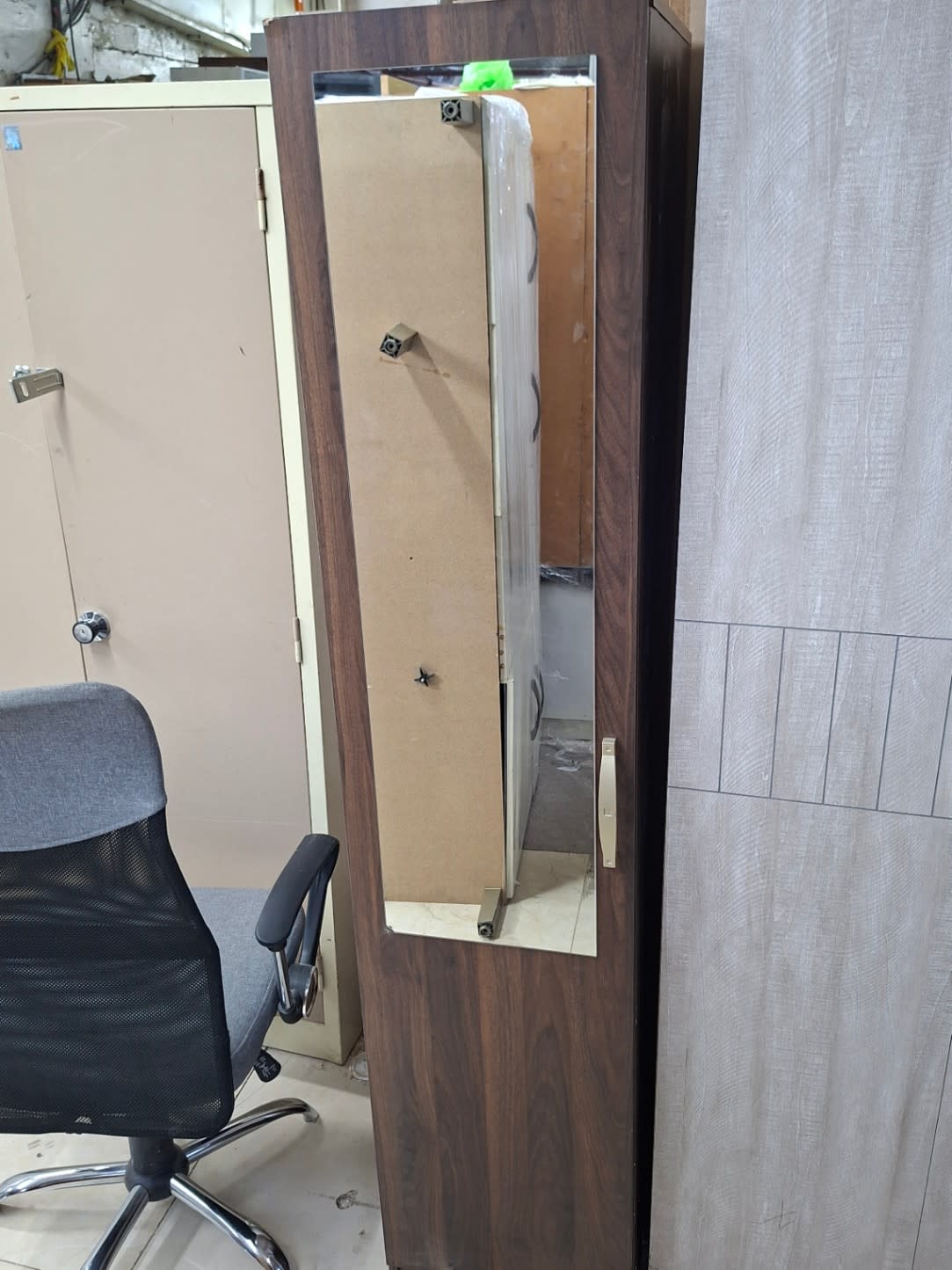 Mirror door of used single door wardrobe open showing door-mounted mirror and internal fittings
