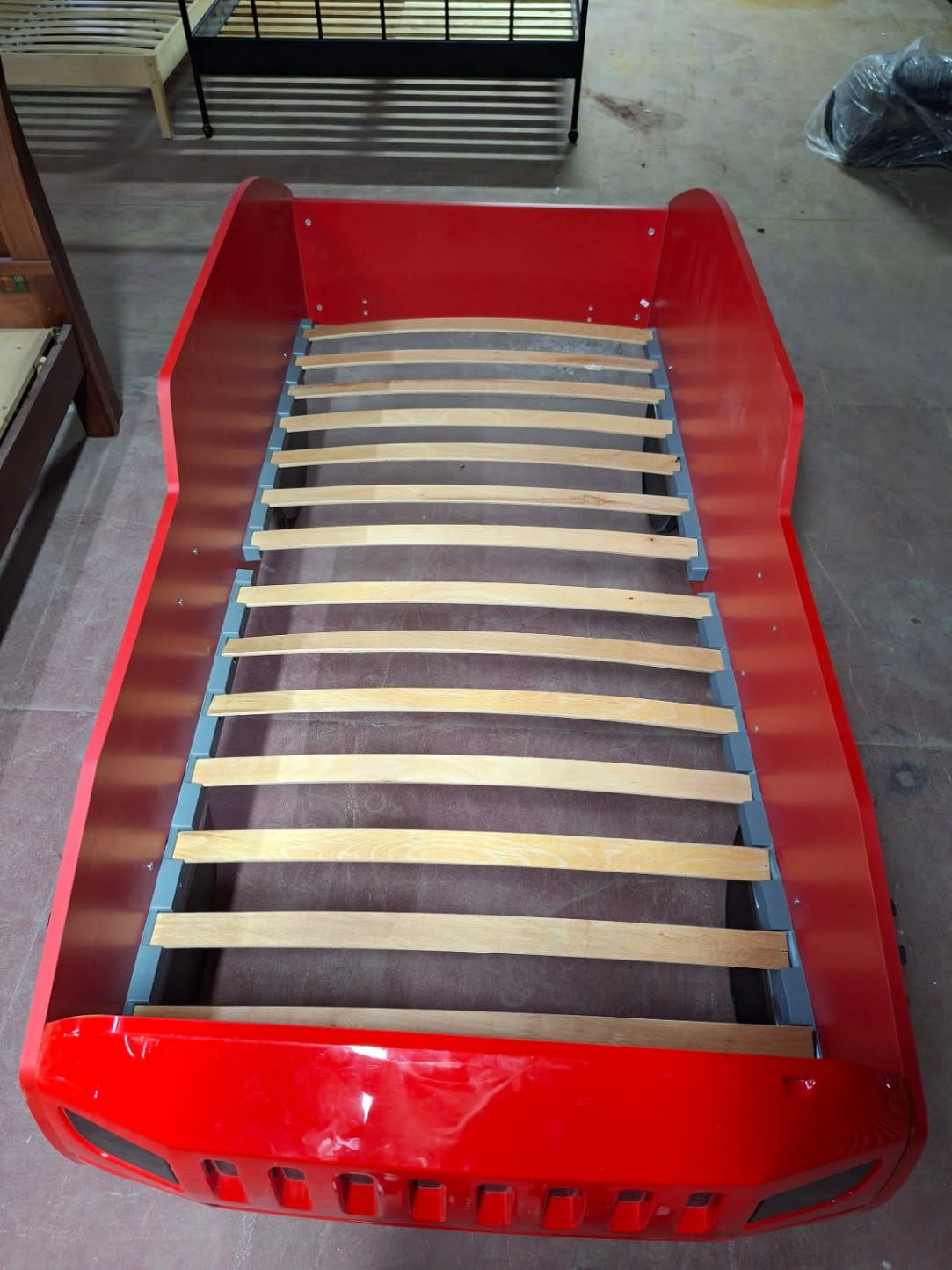 Top-down view of used red 4x4 Jeep kids single bed showing all wooden slats intact