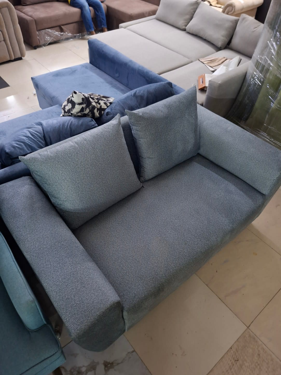 Top-down view of new grey-blue 2-seater sofa with cushions at Bufaisal Shop D Ajman
