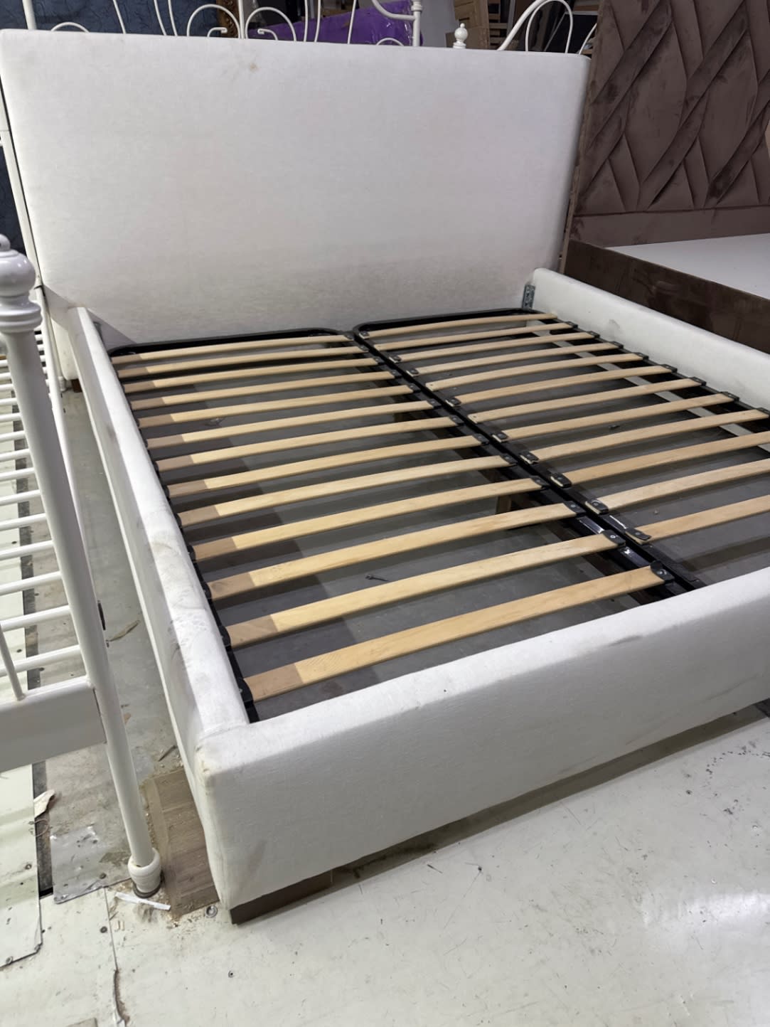 Used white upholstered queen bed frame corner and footboard detail at Bufaisal Shop A Ajman