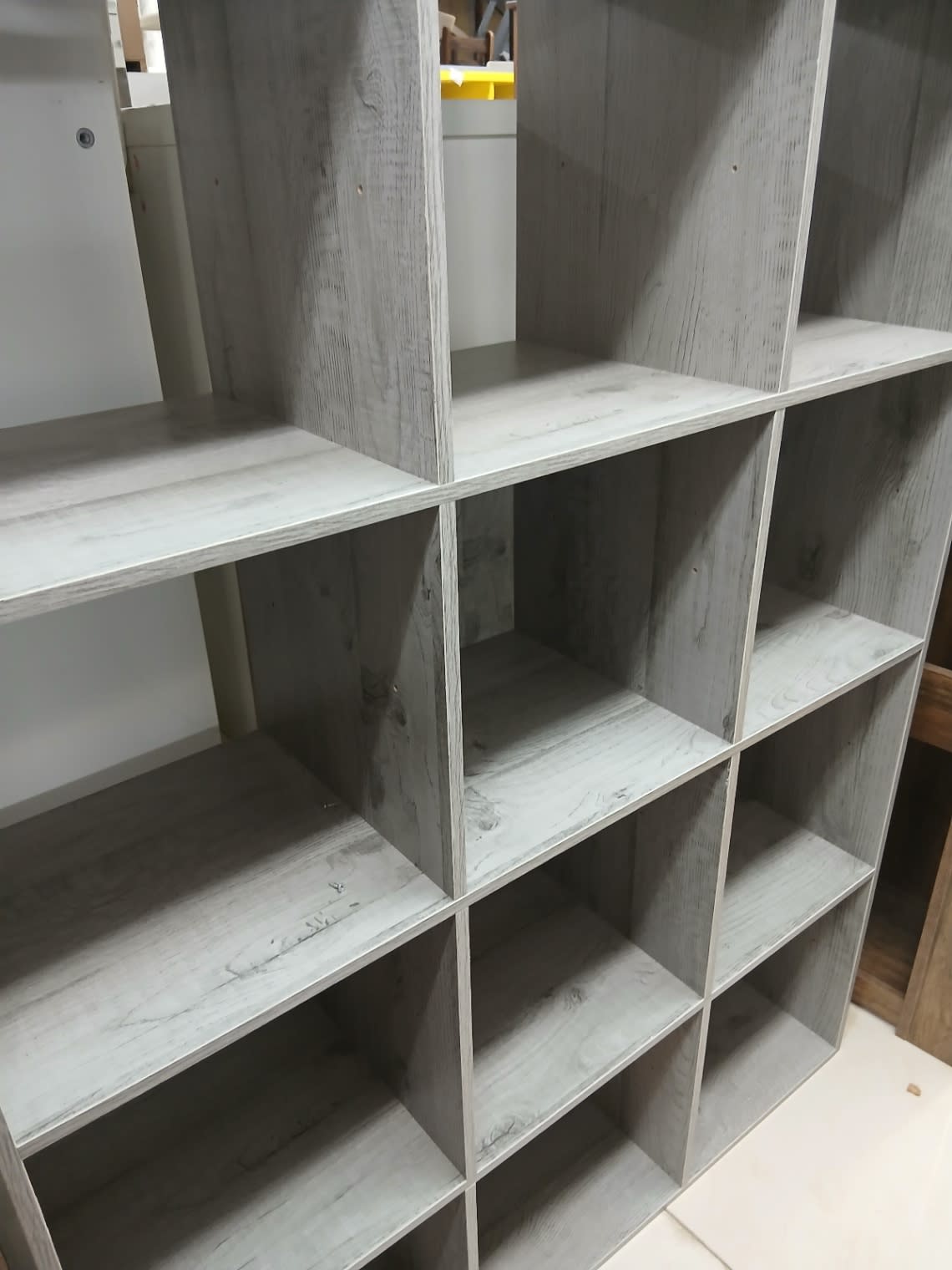 Close-up detail of grey wood-effect cube shelving unit showing shelf surface condition