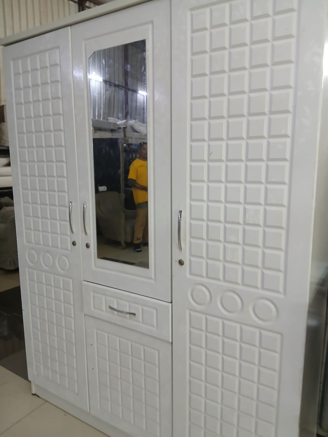 Close-up angle of new white 3-door wardrobe with mirror and embossed panel doors at Bufaisal Ajman