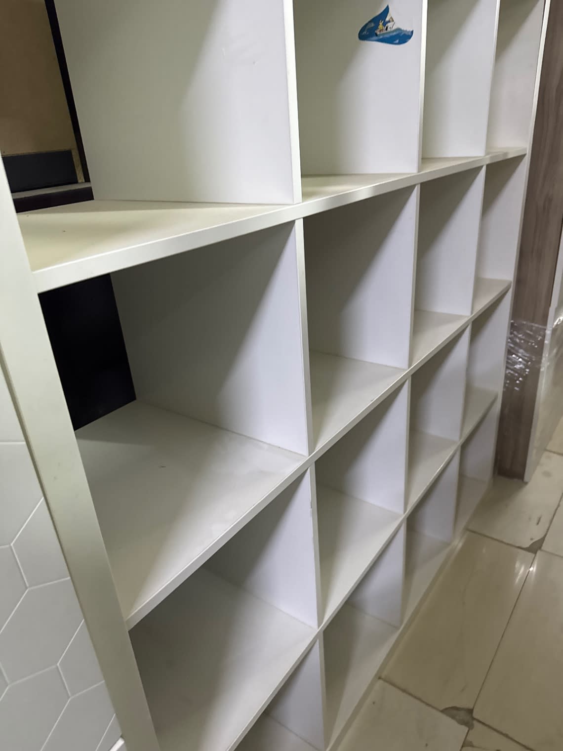 Side detail view of used white open cube bookshelf showing lower compartments at Bufaisal Ajman