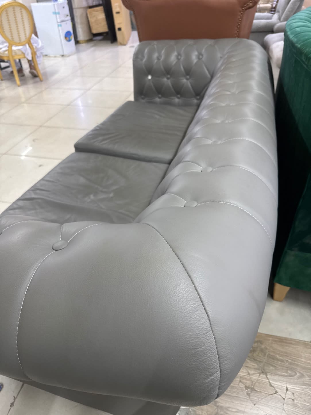 Rear armrest detail of used grey Chesterfield 3-seater sofa at Bufaisal Ajman