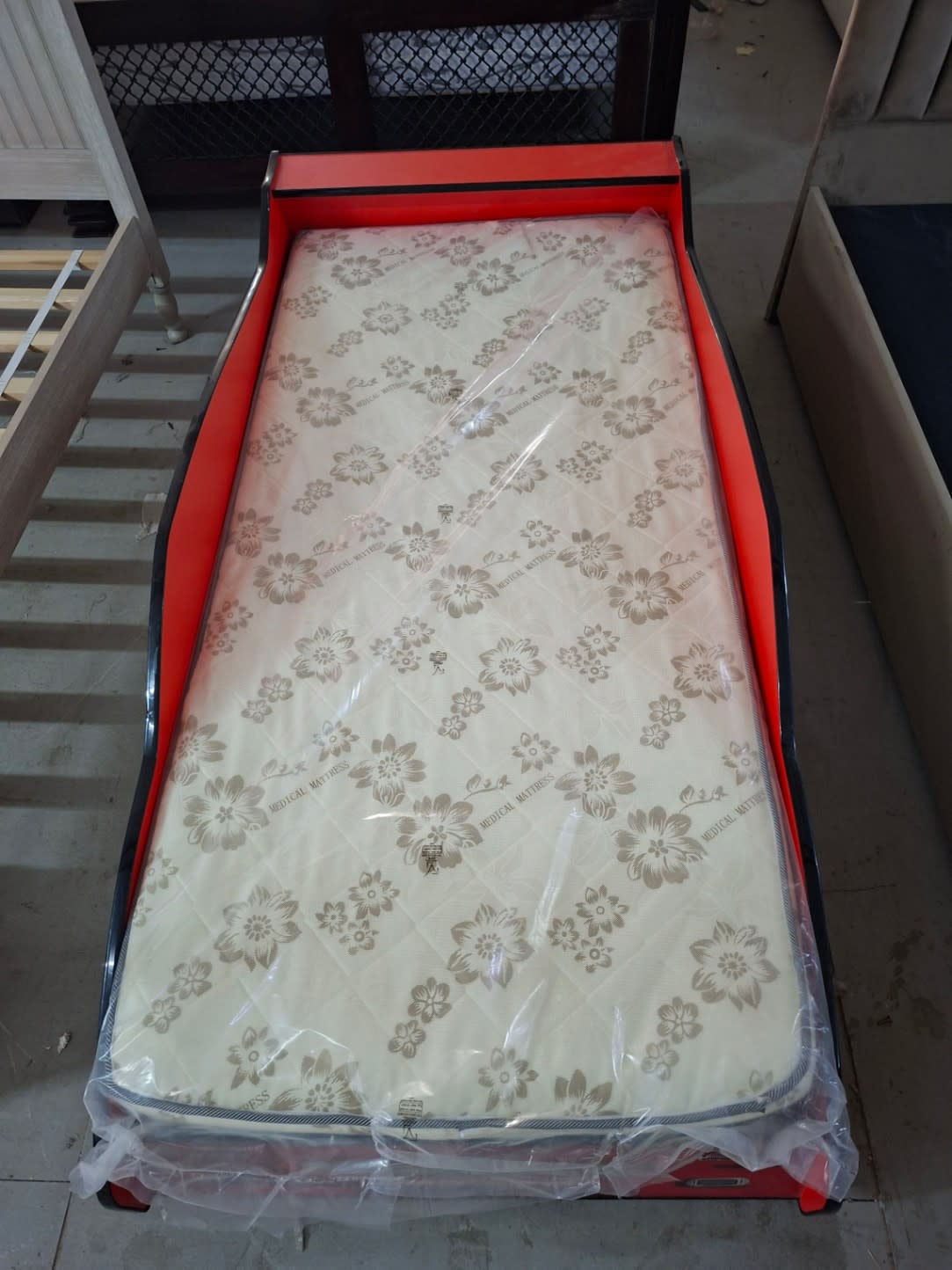 Overhead view of used race car kids bed 90x190 with medical mattress included