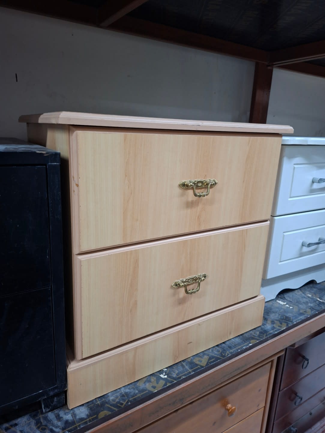 Side angle view of used light beige 2-drawer nightstand with brass handles at Bufaisal Ajman