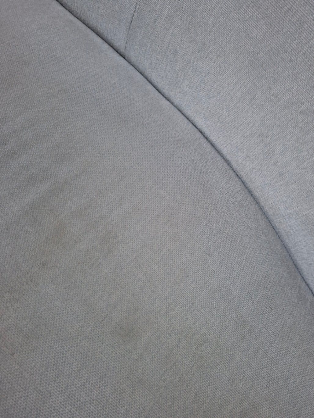Close-up of light grey fabric upholstery on used curved 3-seater sofa at Bufaisal Ajman