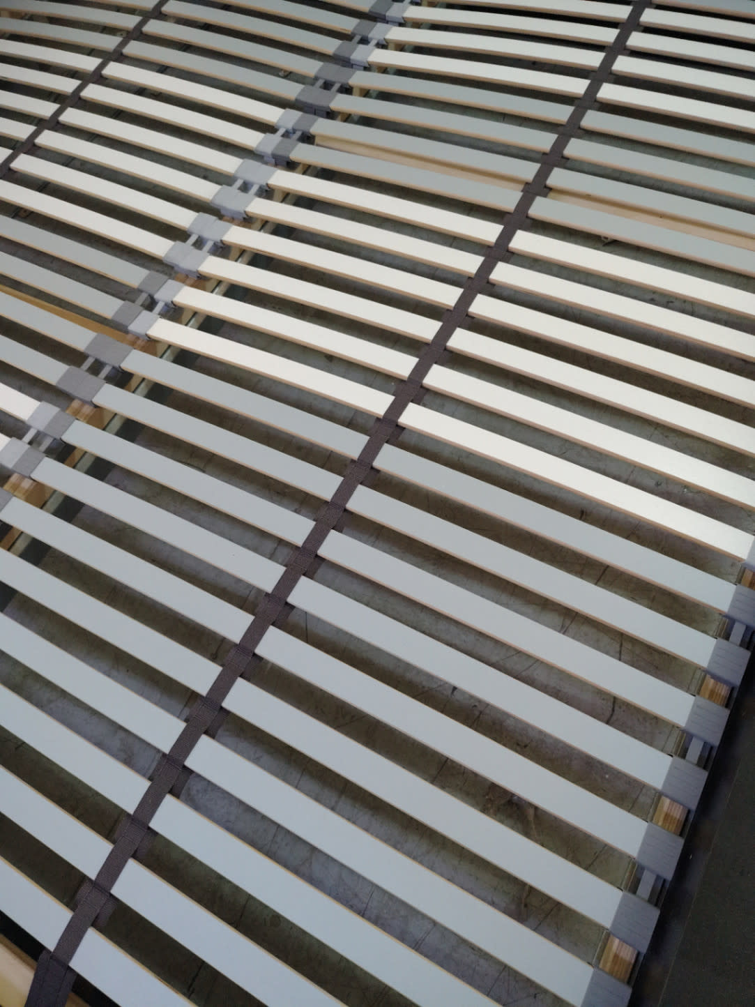 Close-up of wooden slats and fabric cross-ties on used king bed frame at Bufaisal