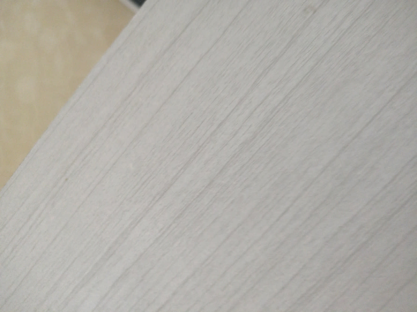 Close-up of white MDF panel surface of used queen bed frame at Bufaisal Ajman