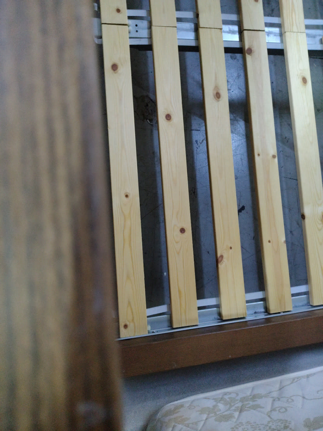 Close-up detail of pine wood slats and metal rails on used queen bed frame Bufaisal