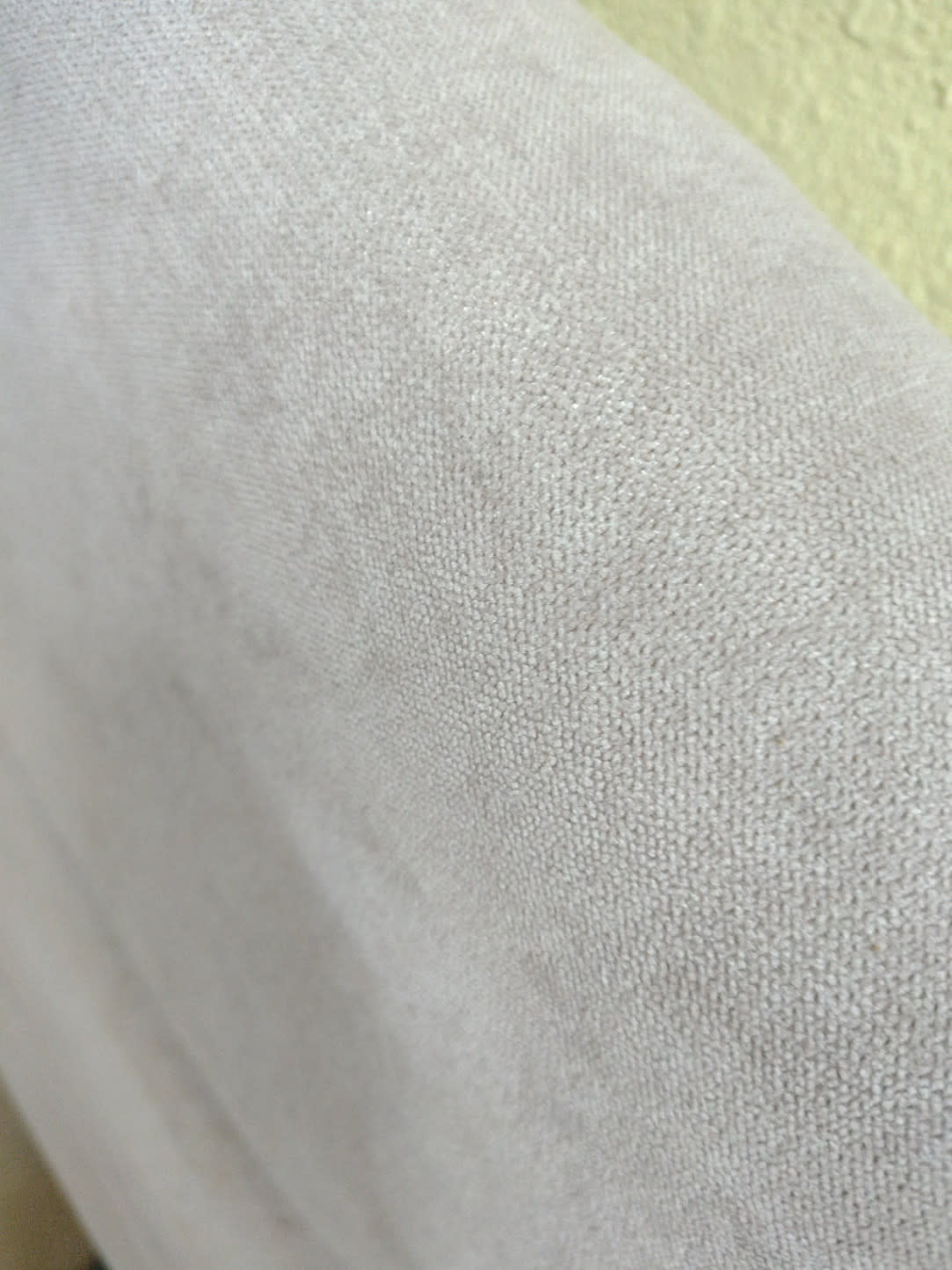 Close-up of light grey fabric upholstery on used queen bed frame showing minor surface wear