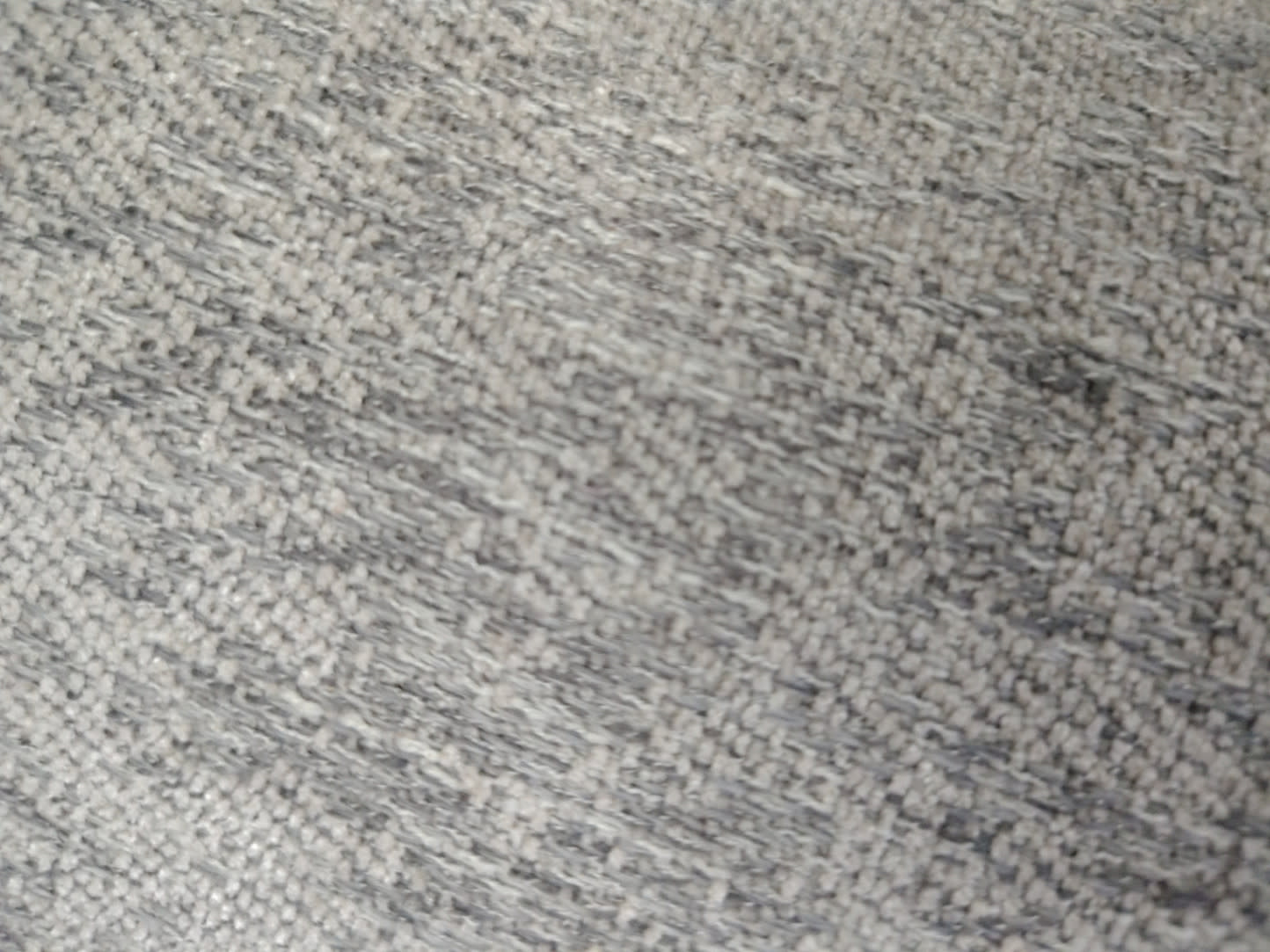 Close-up of light grey woven fabric upholstery on used single armchair at Bufaisal Ajman