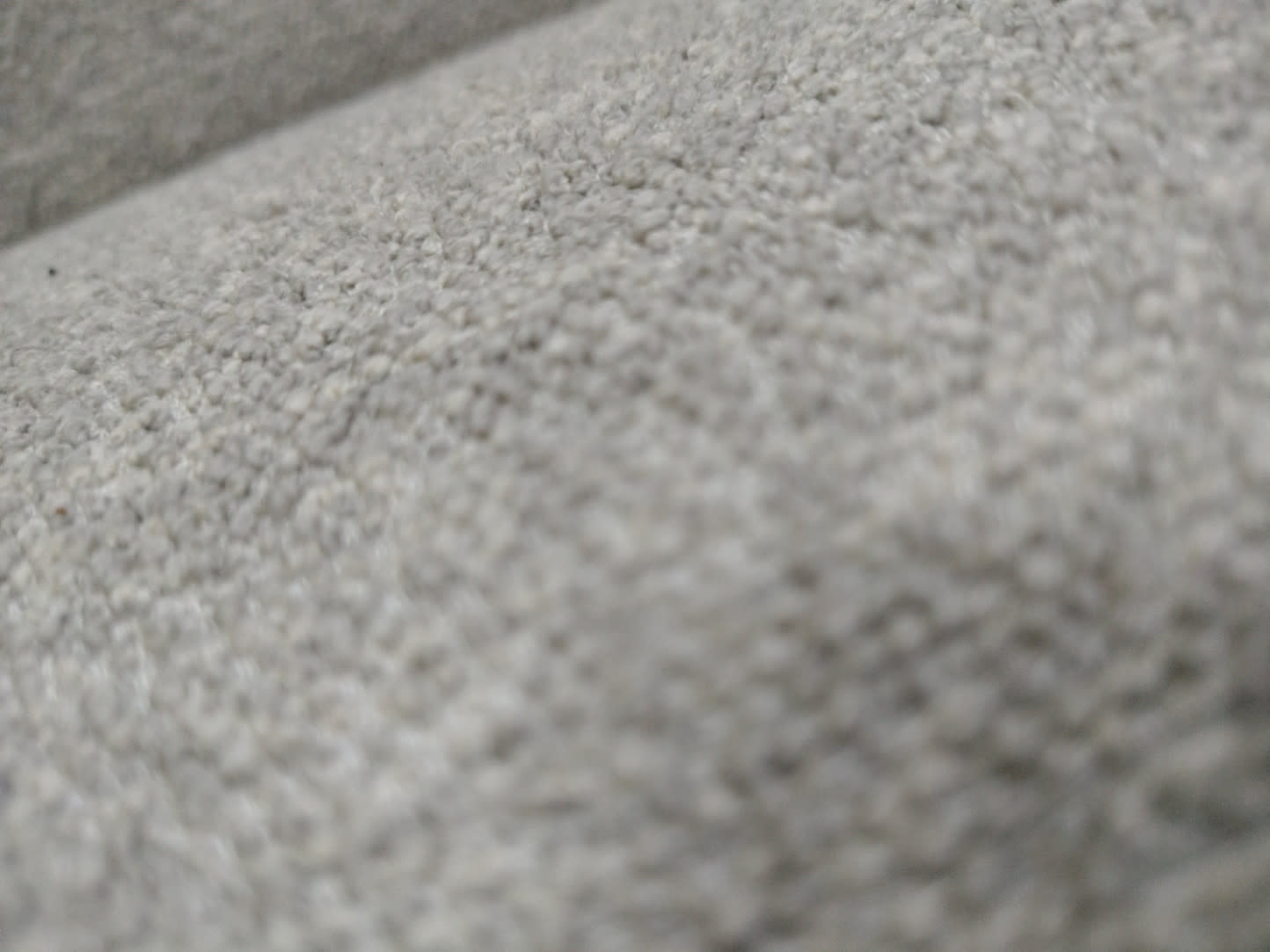 Close-up of light grey boucle fabric texture on used 2-seater sofa at Bufaisal Ajman