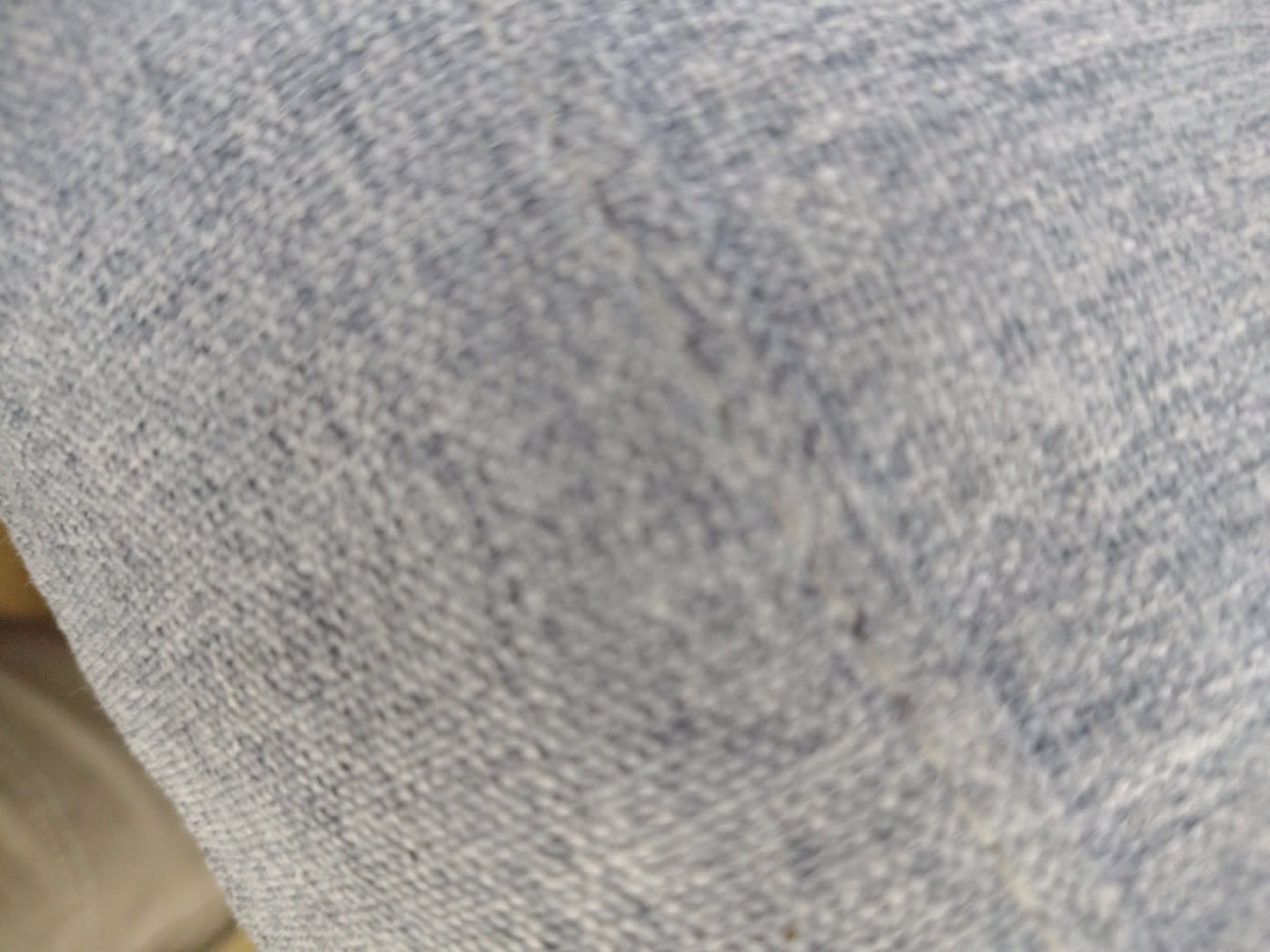 Close-up of teal blue fabric upholstery on new 2-seater sofa showing minor surface scuff