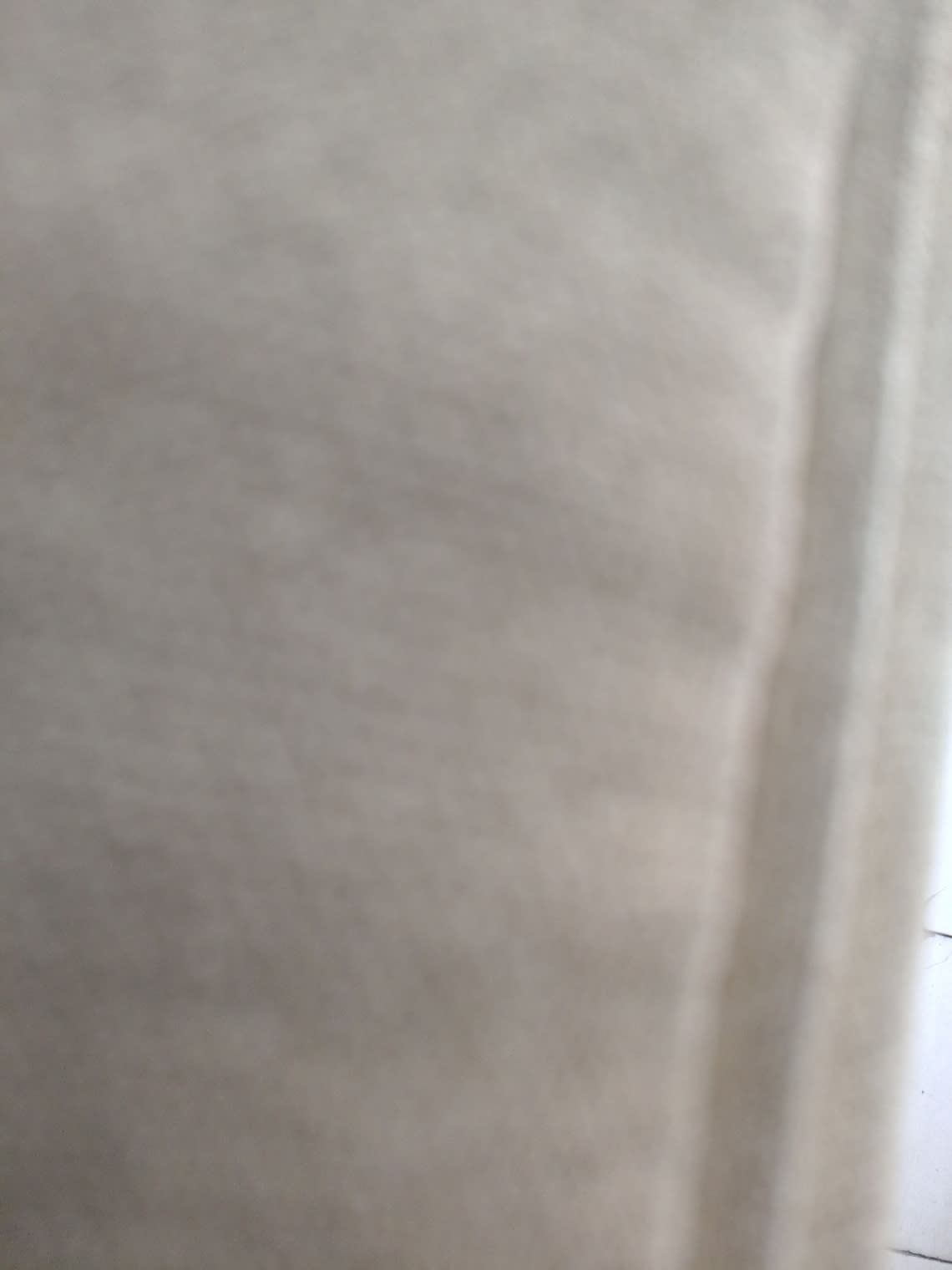 Close-up of beige fabric upholstery on used Chesterfield-style armchair at Bufaisal Ajman