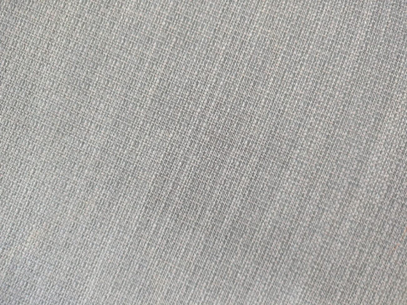 Close-up of dark grey woven fabric upholstery on used L-shape sectional sofa