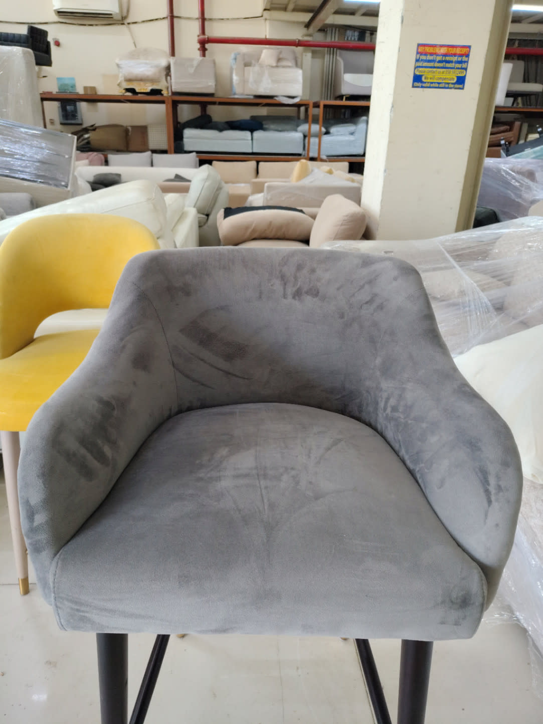Close-up front seat view of used grey velvet bar stool showing fabric condition
