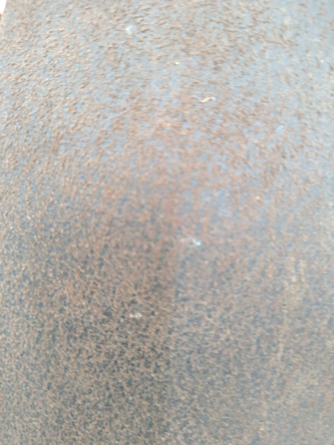 Close-up of brown microfibre fabric on used recliner armchair showing surface soiling and pilling