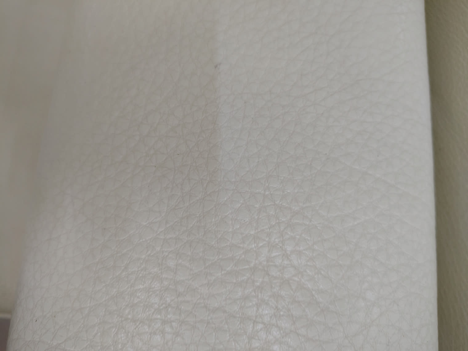 Close-up of cream leather upholstery texture on used single-seat armchair at Bufaisal Ajman