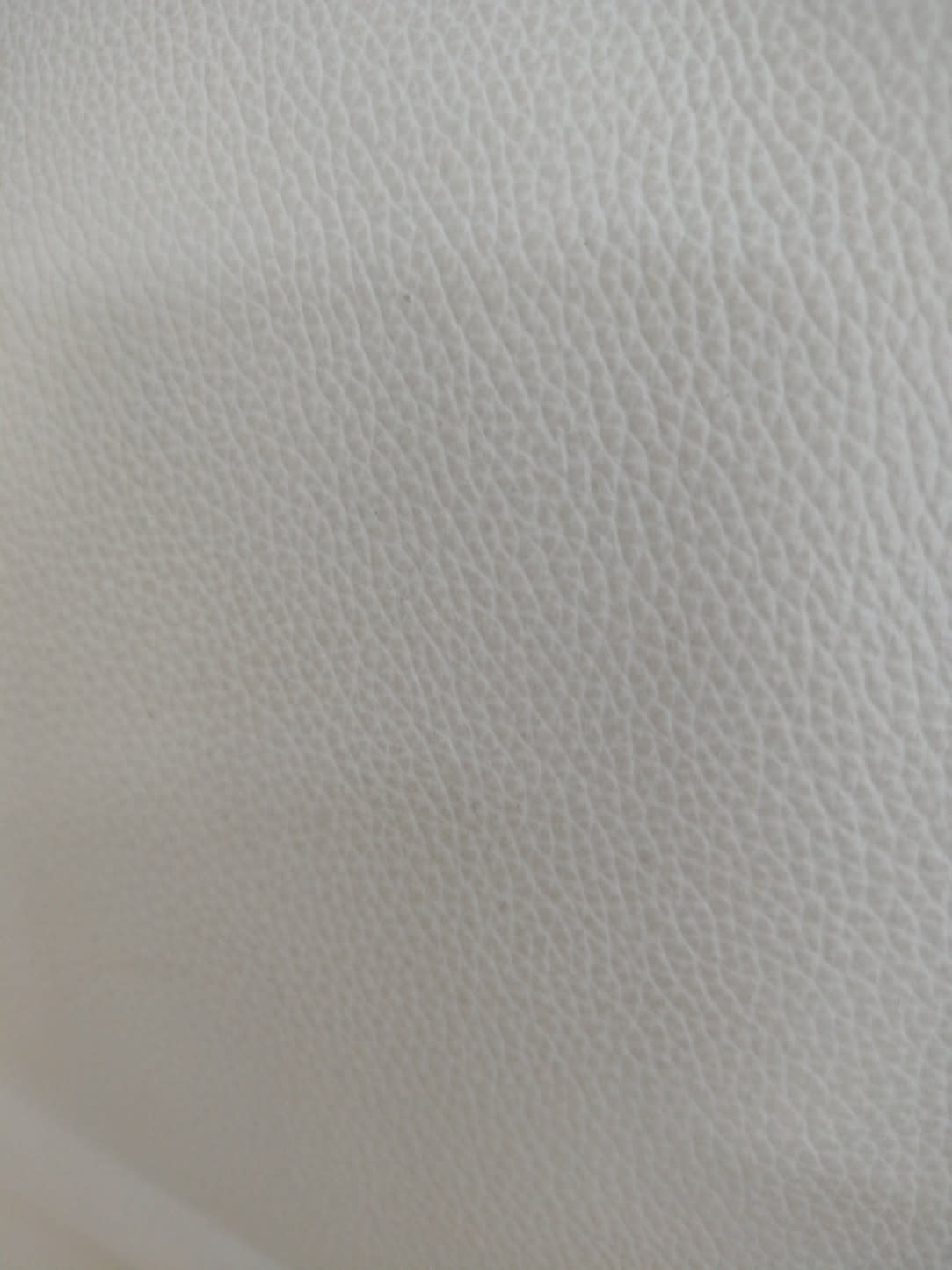 Close-up of pebble-grain leather-look upholstery on used beige armchair at Bufaisal Ajman