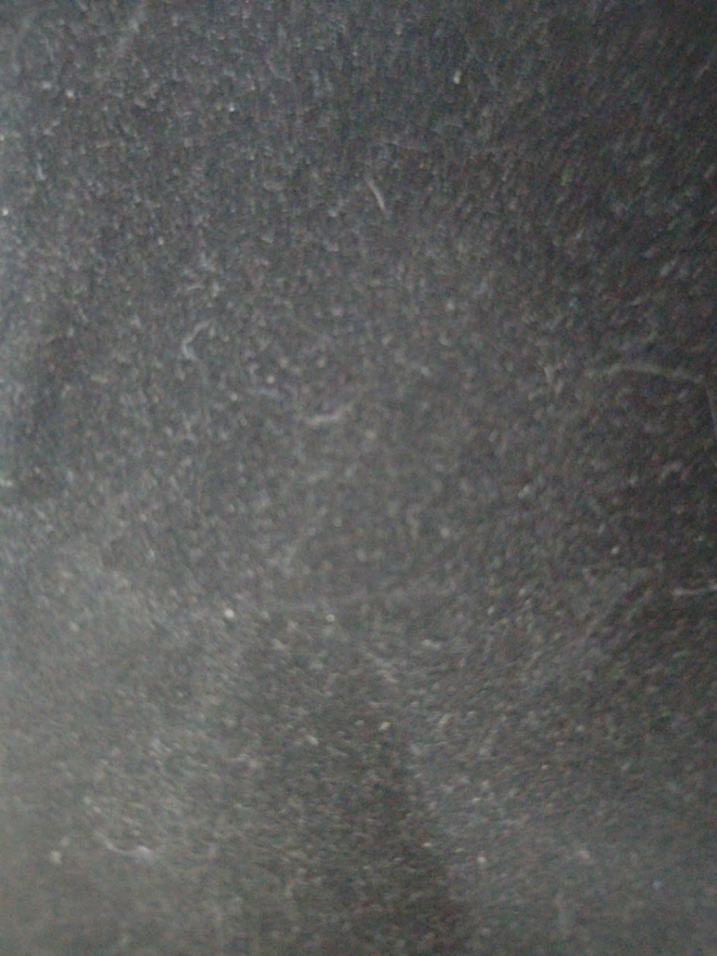 Close-up surface detail of used metal filing cabinet dark grey showing wear and scuffs