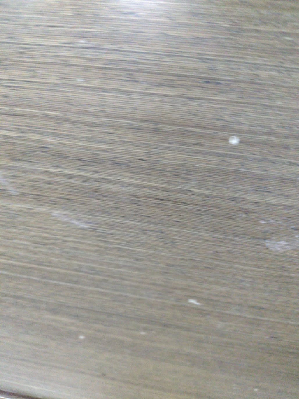 Top surface of used TV stand showing wood-effect laminate with surface scratches at Bufaisal Ajman