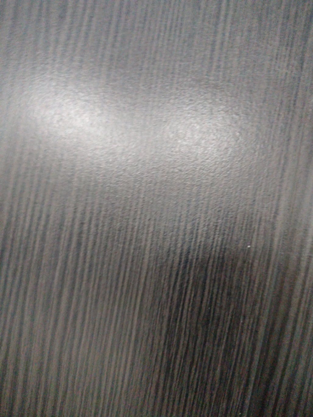 Close-up of dark espresso wood-grain laminate surface of used TV stand at Bufaisal Ajman