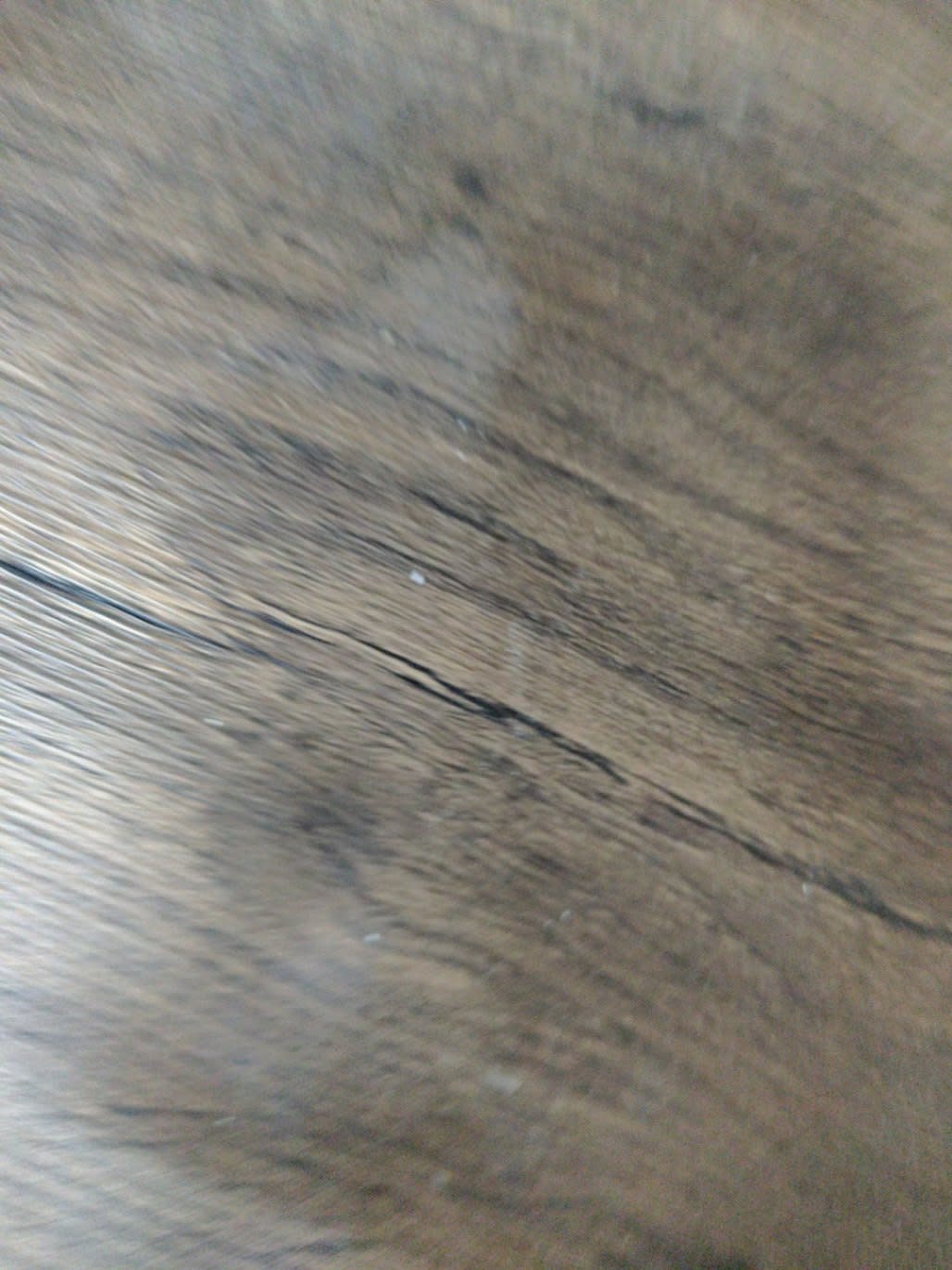 Close-up of surface crack on used dark walnut desk surface sold at Bufaisal Shop C Ajman