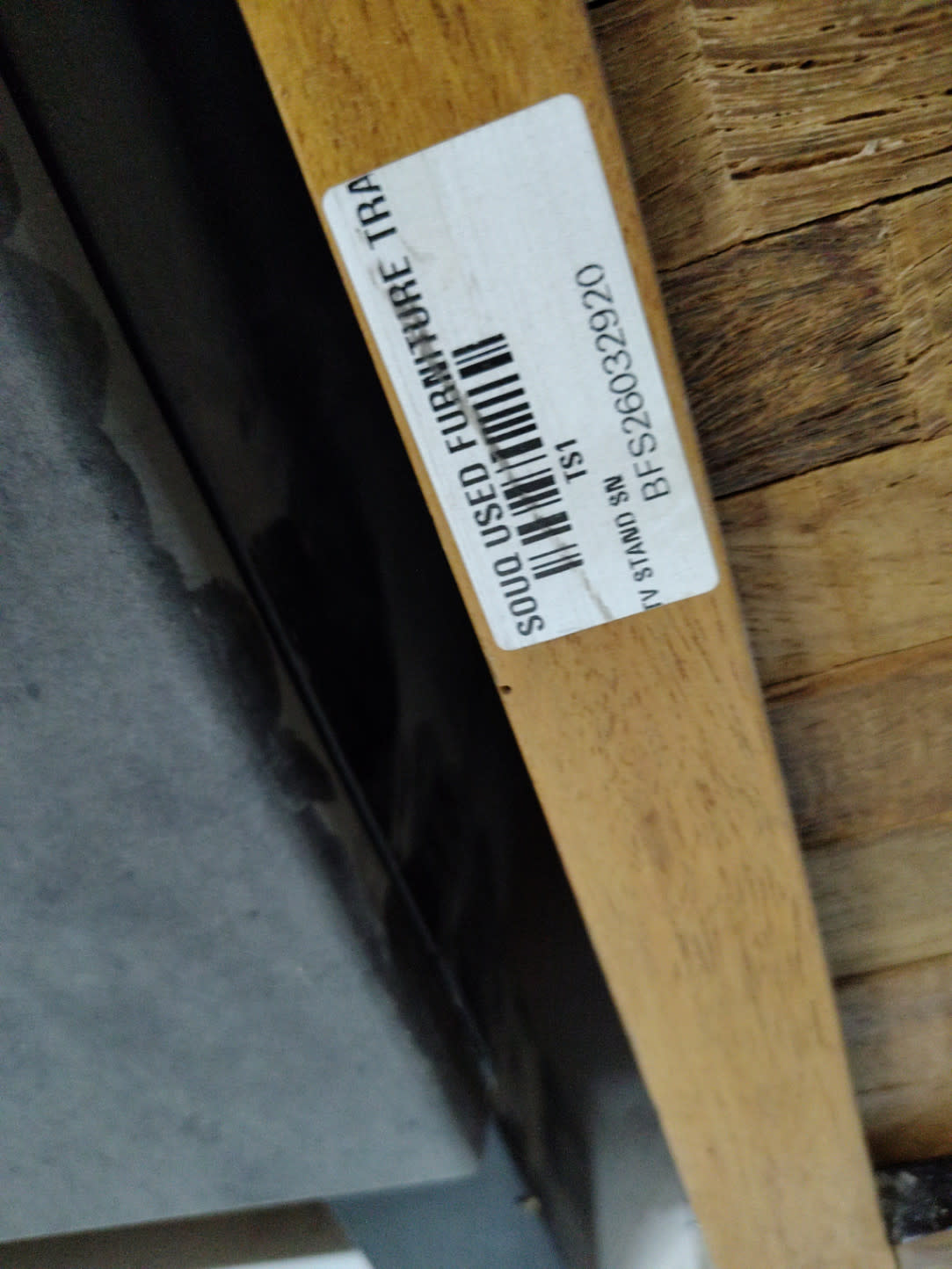 Bufaisal barcode label BFS26032920 for used wooden TV stand at Shop C Ajman