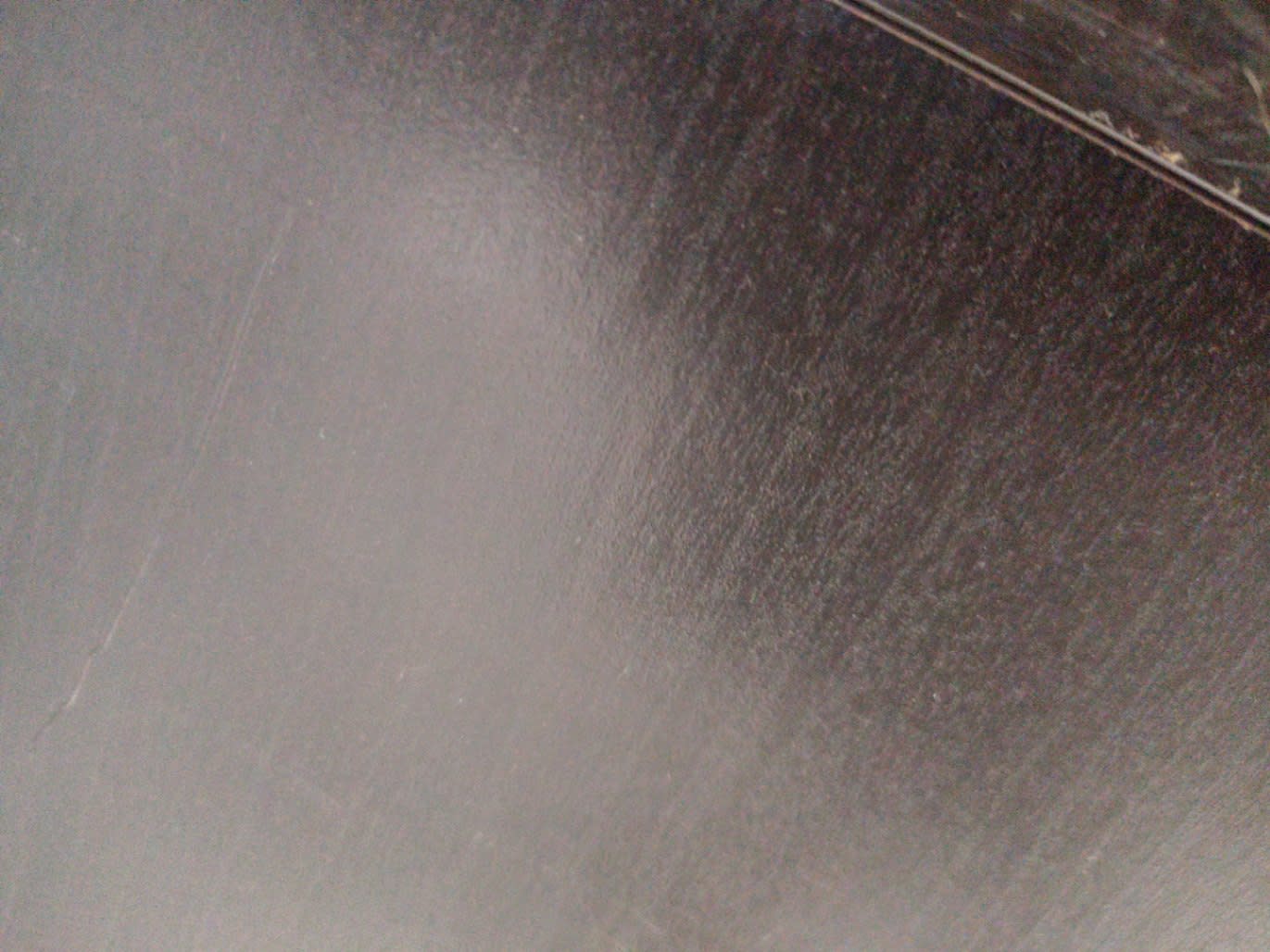 Surface close-up of used grey concrete-effect TV stand showing minor scratches on top panel