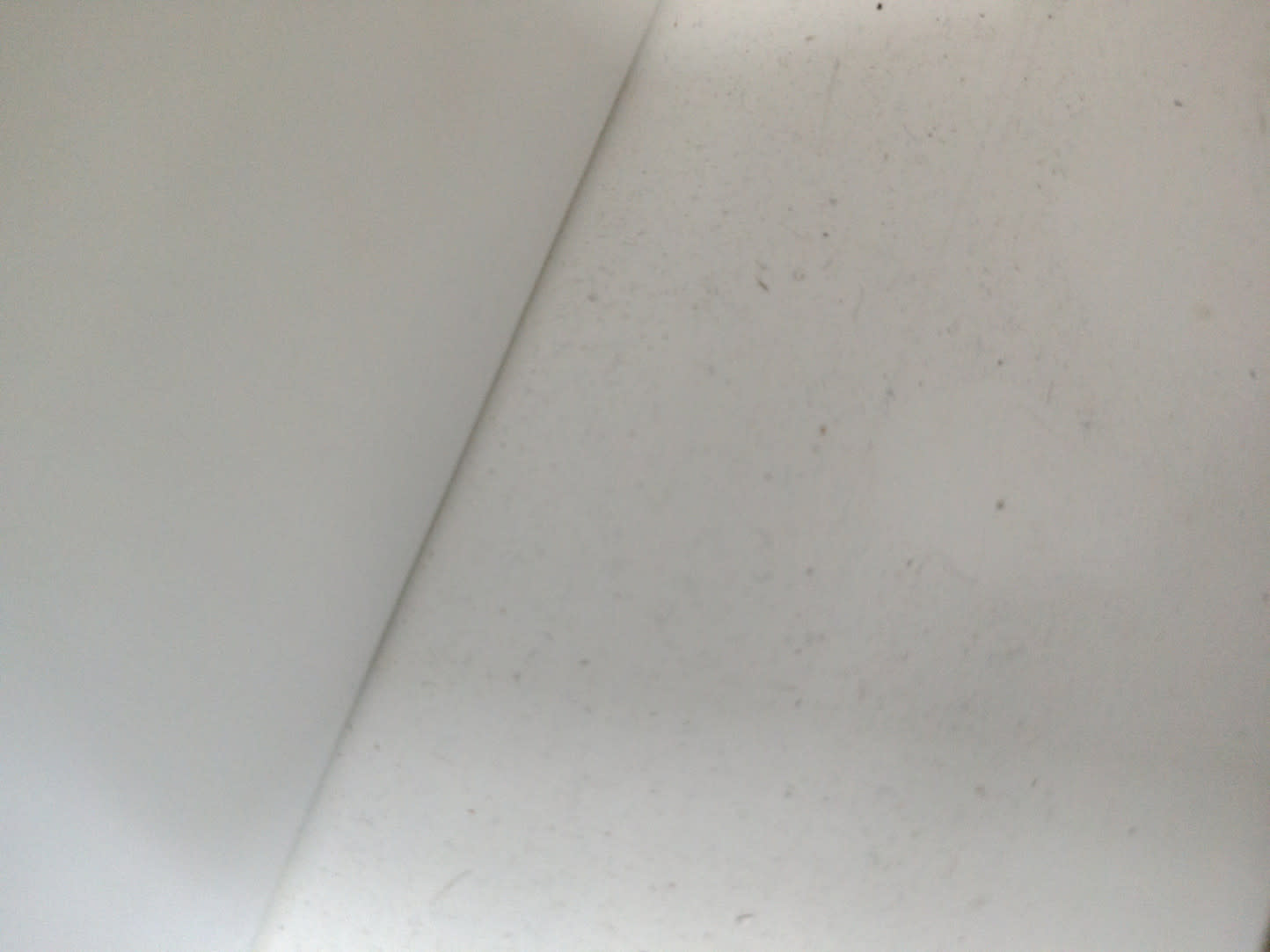 Interior close-up of used white chest of drawers showing minor surface dust and wear