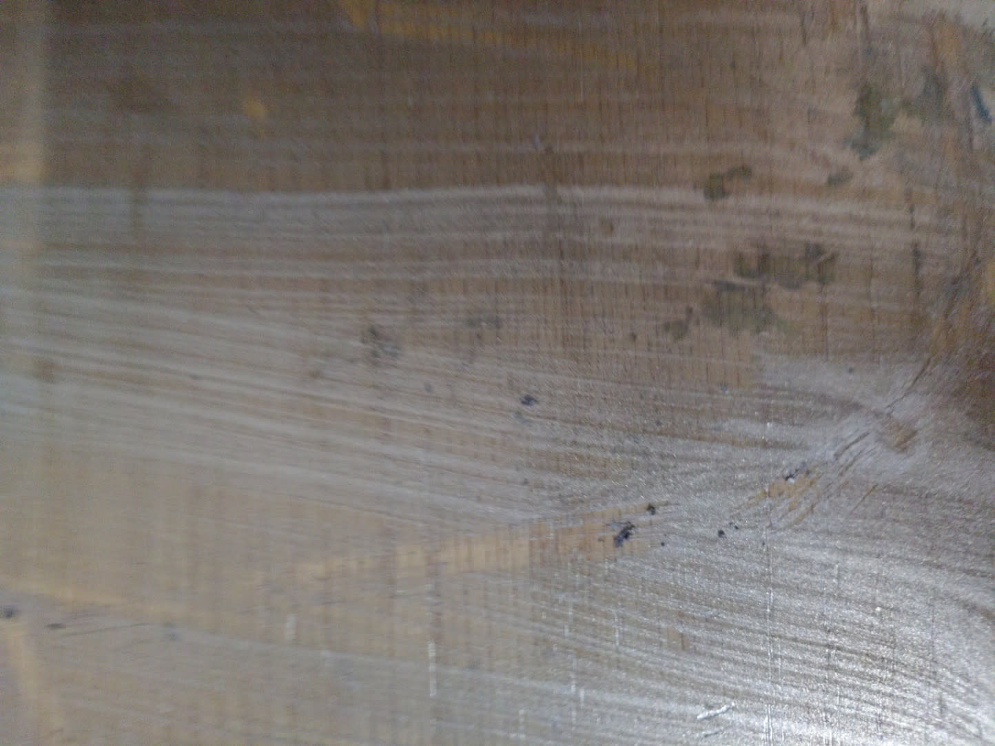 Close-up of surface scratching and scuff marks on used wooden sideboard cabinet door panel