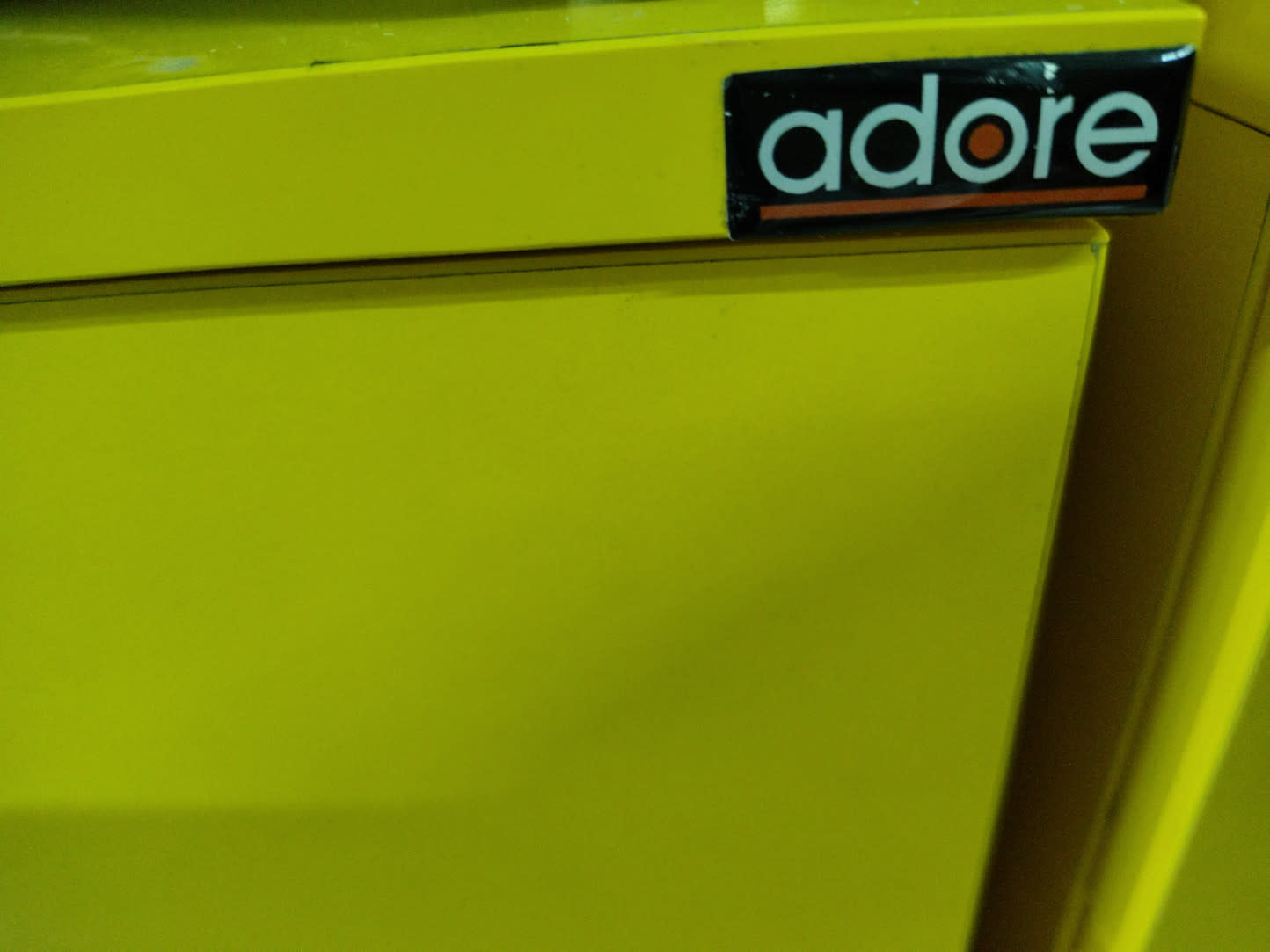 Close-up of Adore brand label on used yellow 5-drawer dresser at Bufaisal Ajman